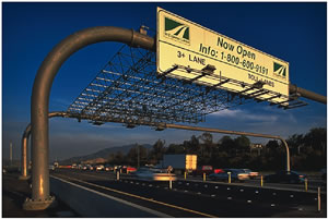 An image of an overhead sign across a road with overhead antennas. Transponders are read by overhead antennas, allowing tolls to be paid without stopping.