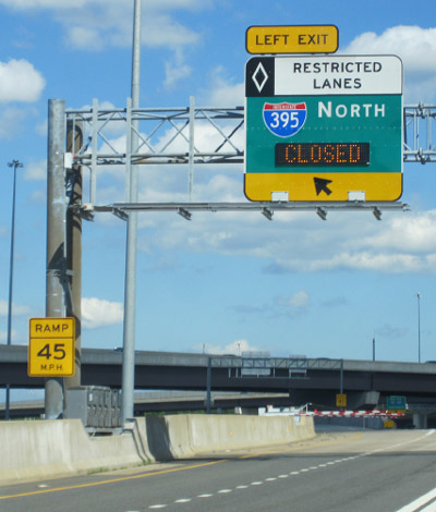 Photo of express lane exit with overhead signage indicating that the exit is closed. Further down the exit closed gates are visible.
