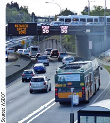 Picture of a bus and cars on a freeway with overhead lane control signage. Source: WSDOT