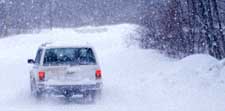 An image of a vehicle driving in a snow storm.