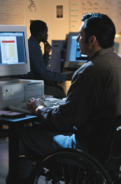 Photograph of a man working at a computer.