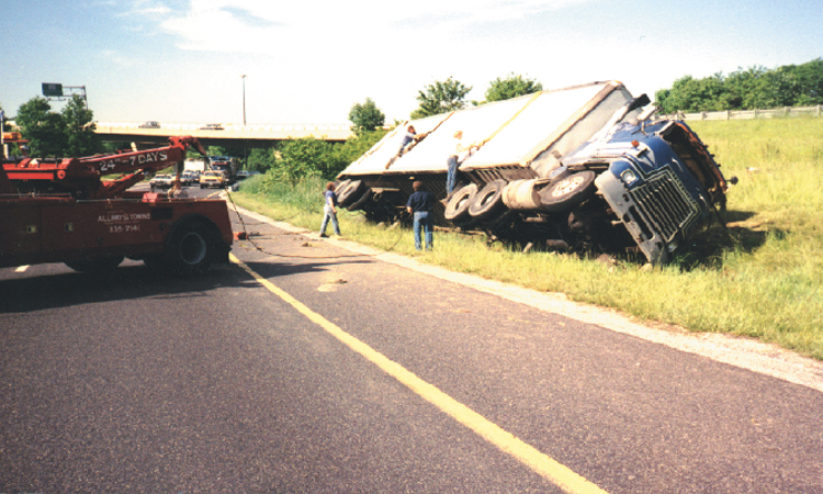 Photograph showing an overturned  tractor on the side of a