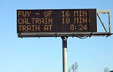 Photo. Example of Active Demand Management in use in California. Sign includes travel time for FWY-SF and CALTRAIN and arrival time of train.