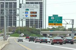 Picture of MnPass facility in Minnesota stating "Car pools, buses and motorcycles (are) Free" while displaying toll rates for non-exempt vehicles.