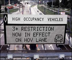 Picture displaying a sign reading "HOVs – 3+ Restriction Now In Effect on HOV Lane"