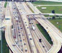 Photo. Aerial photo of Houston HOV lanes and general purpose lanes in use.  Heavier traffic is on the general purpose lanes