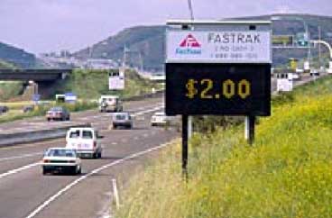photo of a changeable message sign located next to an entrance ramp to I-15 indicating a FASTRAK HOT fee of $2.00