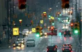 Figure 24: Photo: Arterial roadway with many signalized intersections showing confusing array of traffic signals on a rainy day.