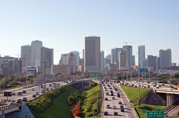 Photo. Traffic traveling on several highways leading into the downtown area of a city.