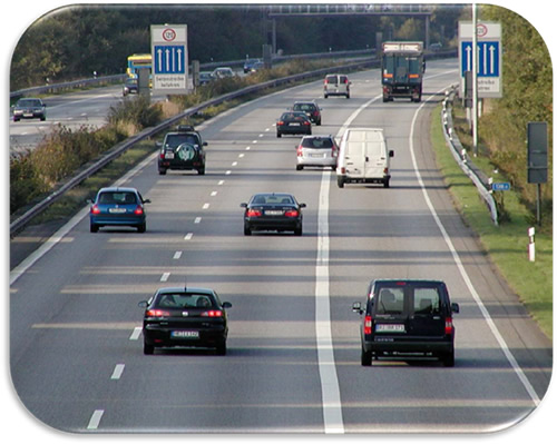 Figure 5. Photo. Temporary Shoulder Use-Germany. Photo showing temporary shoulder use open on the right shoulder of a German motorway. Ground-mounted signs indicate the open shoulder and the appropriate speed limit.