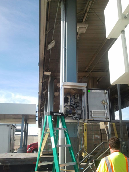 Figure 31. Photo. RFID equipment being installed at CBP primary booth at BOTA. This photo shows radio frequency identification (RFID) equipment being installed at Customs and Border Protection primary inspection booths at the Bridge of the Americas.