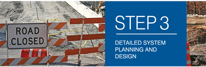 A photograph is provided showing a road construction zone behind a barrier and a sign indicating the road is closed.  STEP 3 - DETAILED SYSTEM PLANNING AND DESIGN