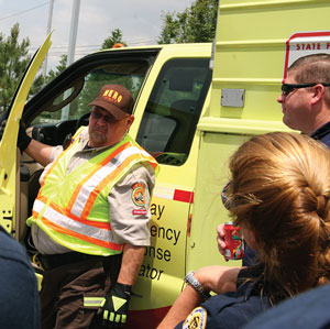 Photo of TIM responders talking outside of an official vehicle.