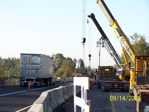 Photo of cranes in work zone next to temporary lane marked with cones