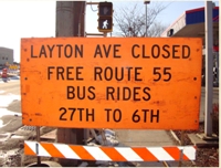 Photo of an orange sign advising travlers that Layton Avenue is closed but there are free bus rides for those affected during the work zone construction period.