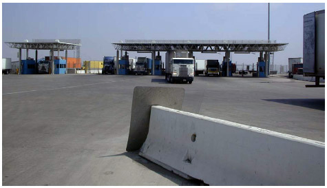 A photo of U.S. Customs primary inspection booths, showing trucks exiting tollbooths.