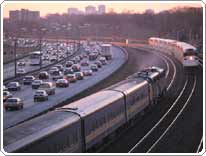 mass transit rail cars pass near congested highway