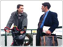 man on bike talking to man holding briefcase