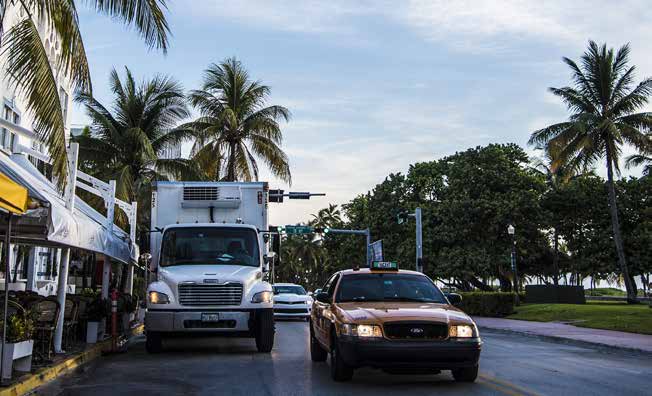 photo of vehicles passing a parked delivery truck on a Miami Beach street