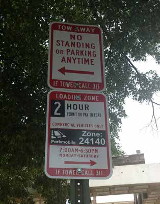 photo of two signs on a post: Tow Away Zone and Loading Zone