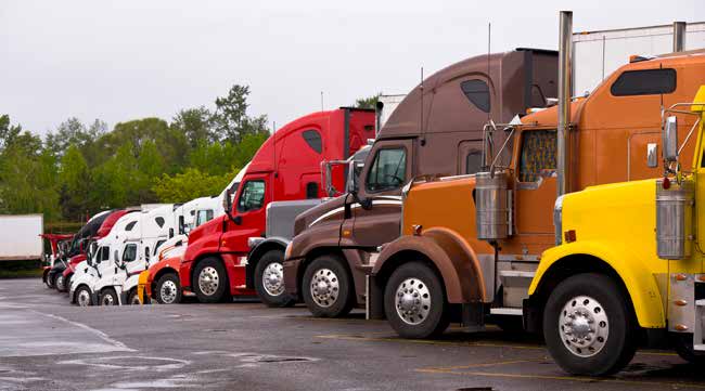 photo of tractor-trailers parked in a line at a truck stop