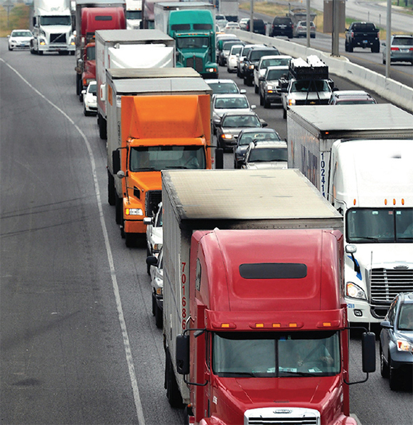 Highway traffic with 18-wheeler freight trucks.