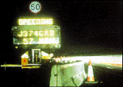 night photo of portable message board showing speed of approaching traffic