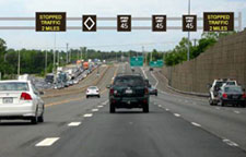 Photo. Example of Active Traffic Management in use in Virginia.  Signage includes speed limits over 3 travel lanes and textual information in far left and far right lanes.