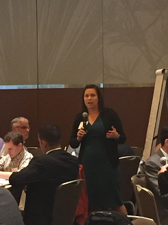 Image of Illinois Department of Transportation Office of Planning and Programming Director, Erin Aleman, speaking to a group of participants siting around tables.