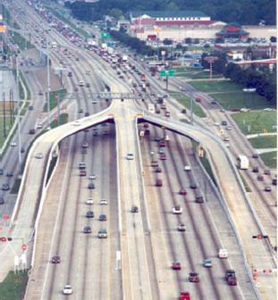 Figure 9: This photo illustrates direct access ramp to the HOV lane on Gulf Freeway (I-45S) in Houston.  The ramp to the HOV lane, located in the freeway median come from the freeway and frontage roads.  The ramps are elevated over the general-purpose freeway lanes.  This figure helps the reader understand the design and operation of the direct access ramps to the freeways and frontage roads associated with the Houston HOV lanes.