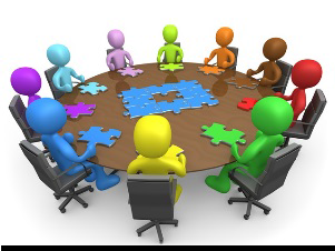 A cartoon round table with people figures in various colors such as red, purple, green, orange, yellow, blue, indigio and violet.  Each figure has a puzzle piece on the table next to them.  In the center of the table is a puzzle with the center puzzle piece missing.