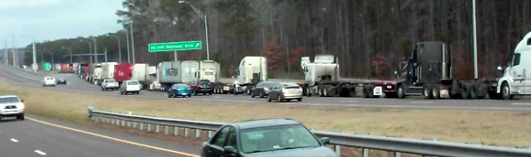 Image of a series of mack trucks on a highway.