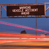 Overhead road sign that says "Warning Vehicle Accident Ahead".