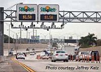 Photo. Overhead signs identifying the current SunPass toll rate as $1.50 in Miami, Florida.