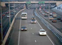 Photo. View of a Minneapolis roadway with vehicles using toll lanes and general purpose lanes.  The toll lanes are less congested.