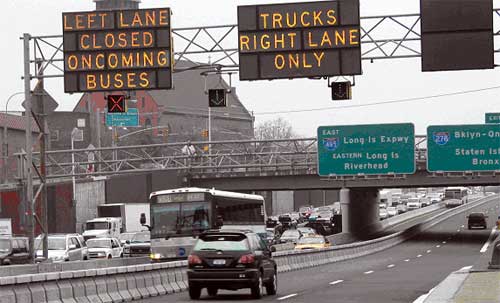 photo of a managed lane facility operating in New York City during the morning peak period. Attributes shown include a contraflow inbound bus and taxi lane operating in the "normal-use" left outbound lane. This bus lane is separated from the outbound general purpose lanes by a moveable concrete barrier. Outbound trucks are restricted to the right lane only