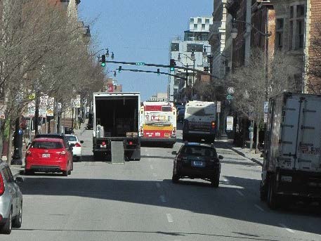 a truck being unloaded on a busy Baltimore street during the day