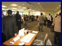 Image of many people standing in a large room attending a meeting or event.