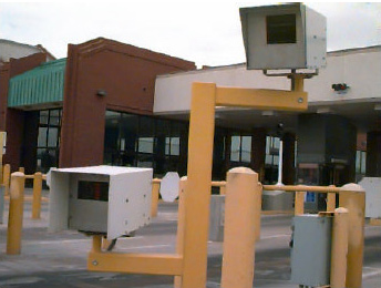 Photo of two license plate readers mounted on supports, one mounted higher than the other.