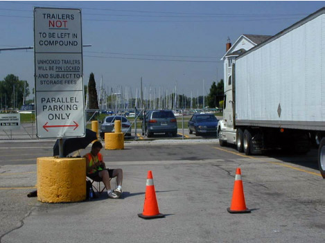 Photo of OB-2 collection location in Canadian Customs parking area, showing sign advising truck trailers not to be left in the compound.