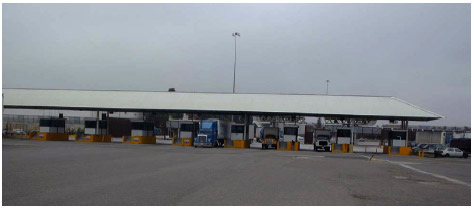 A photo of Mexican Customs primary inspection booths, showing trucks in the tollbooths.
