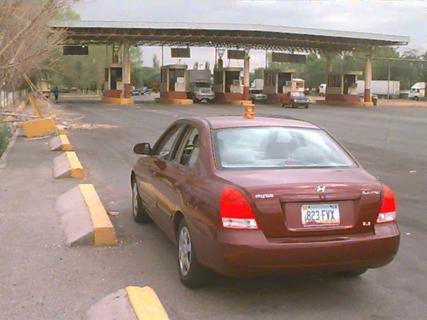 Photo of Outbound 2 data collection point, showing cars and trucks exiting the tollbooth. An official's car is in the foreground.