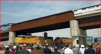 Image of an elevated passenger rail line over a freight rail line in Los Angeles, CA