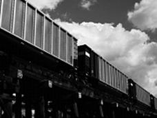 Picture of freight train with containers over rail bridge.