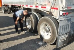 Photo of enforcement officer using portable roadside scale on a semi-tractor trailer.  Source: Richard Easley.