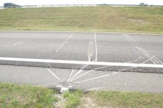 Two photographs showing roads patching that identifies the 3 inch cuts made for installation of the Kistler WIM sensors. Broader photo of the section. Source: Richard Easley.