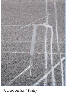 Two photographs showing roads patching that identifies the 3 inch cuts made for installation of the Kistler WIM sensors. Close up of a section in the broader photo. Source: Richard Easley.
