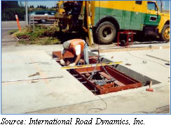 Photograph of a man working on the frame in the pit of a single load cell scale. Source: International Road Dynamics, Inc.