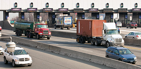 Cars and trucks pass through electronic toll collection station