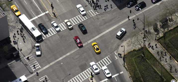 Aerial view of traffic intersection with cars and pedestrians.